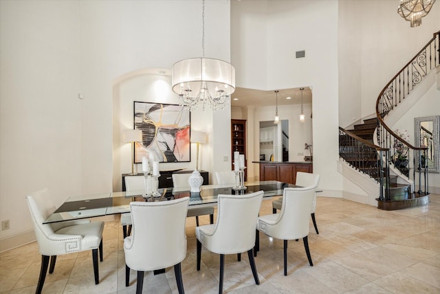 dining room featuring a high ceiling, stairway, baseboards, and an inviting chandelier