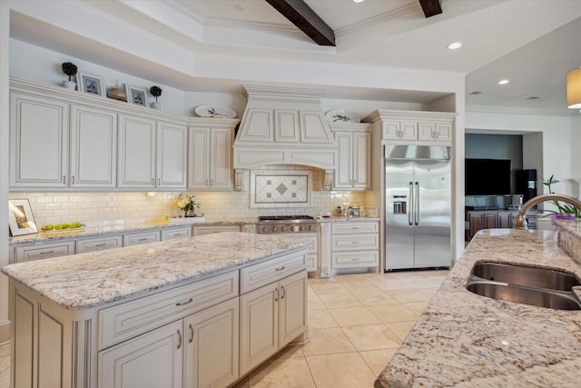 kitchen with built in fridge, a sink, backsplash, and custom exhaust hood