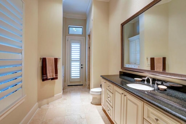 bathroom featuring baseboards, toilet, tile patterned floors, crown molding, and vanity