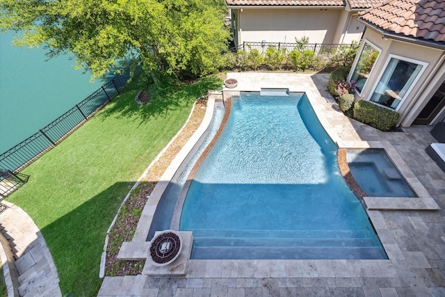 view of swimming pool featuring a pool with connected hot tub, a yard, a patio, and fence