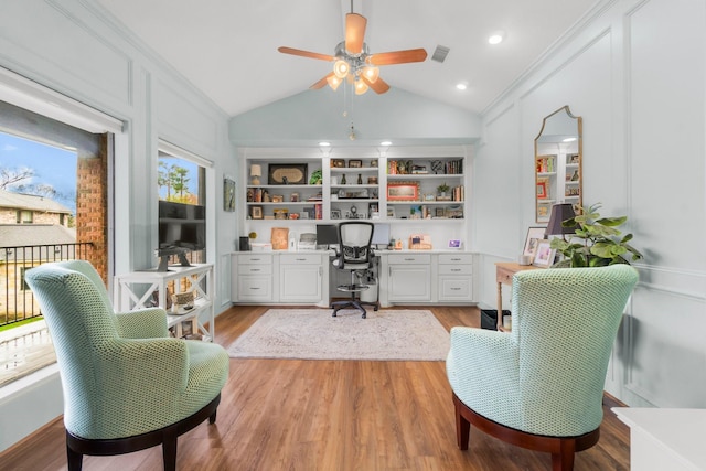 office with built in shelves, visible vents, vaulted ceiling, light wood-type flooring, and built in study area