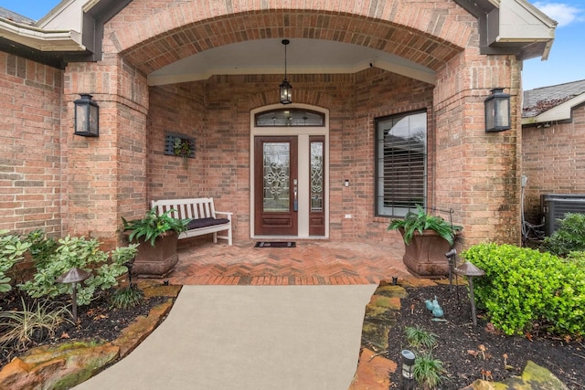 entrance to property with brick siding and central AC unit