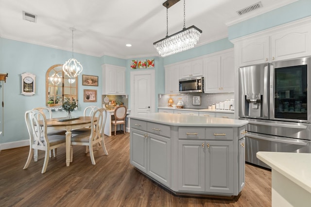 kitchen with visible vents, white cabinets, a kitchen island, appliances with stainless steel finishes, and light countertops