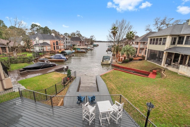 view of community with a dock, a water view, a residential view, and a lawn