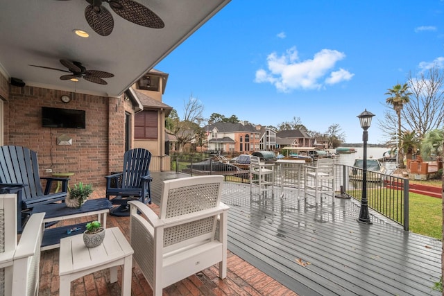 wooden terrace featuring a residential view and a ceiling fan