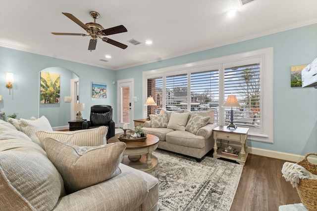 living area featuring ornamental molding, arched walkways, visible vents, and wood finished floors