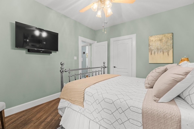 bedroom featuring a ceiling fan, baseboards, and wood finished floors