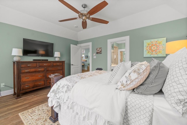 bedroom featuring ceiling fan, connected bathroom, baseboards, and wood finished floors