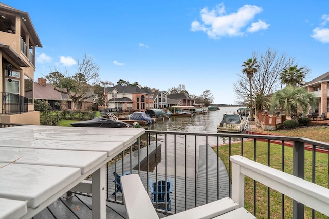 balcony featuring a water view, a residential view, and a boat dock