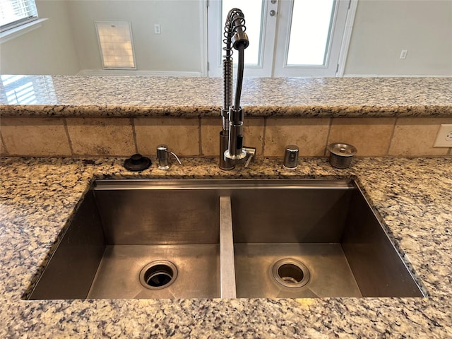 interior details with light stone counters and a sink