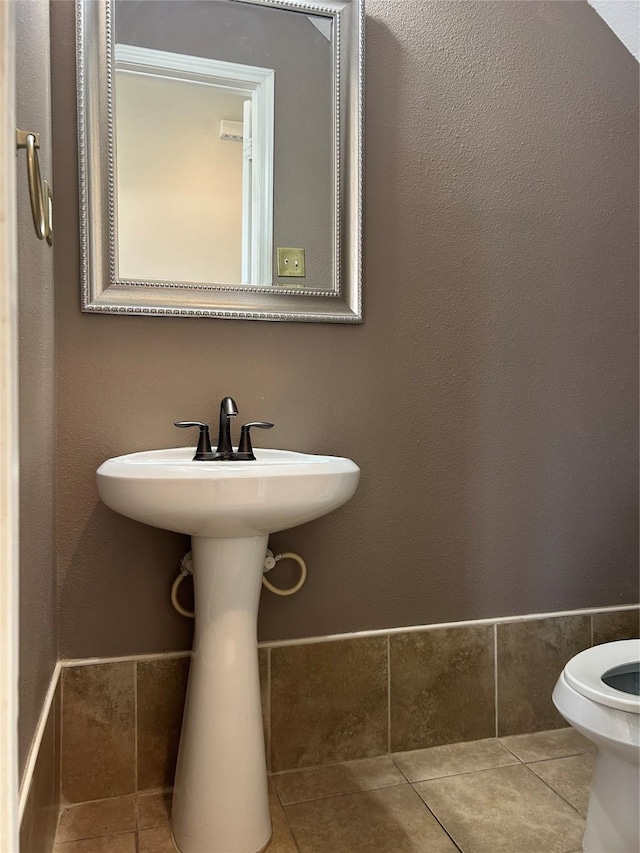 half bathroom featuring toilet and tile patterned floors