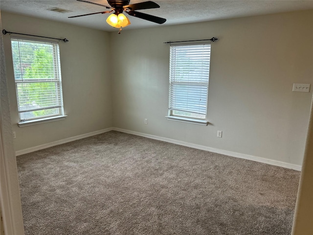 carpeted spare room featuring visible vents, ceiling fan, a textured ceiling, and baseboards