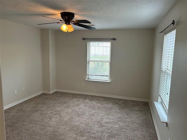 unfurnished room with a ceiling fan, carpet, a textured ceiling, and baseboards