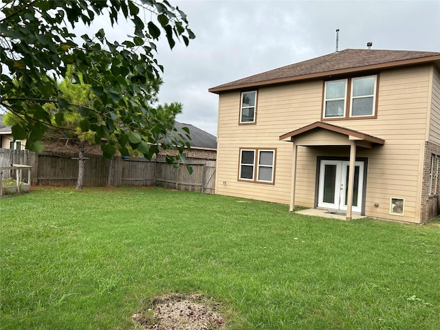 back of house with a fenced backyard, french doors, and a yard