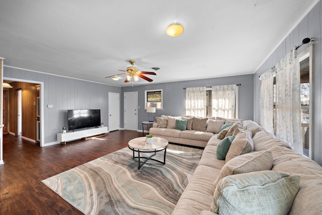 living area featuring ceiling fan, crown molding, baseboards, and wood finished floors