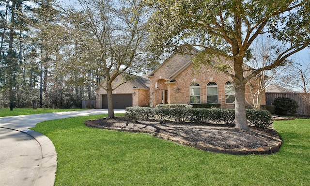 view of front of home with brick siding, concrete driveway, an attached garage, fence, and a front lawn