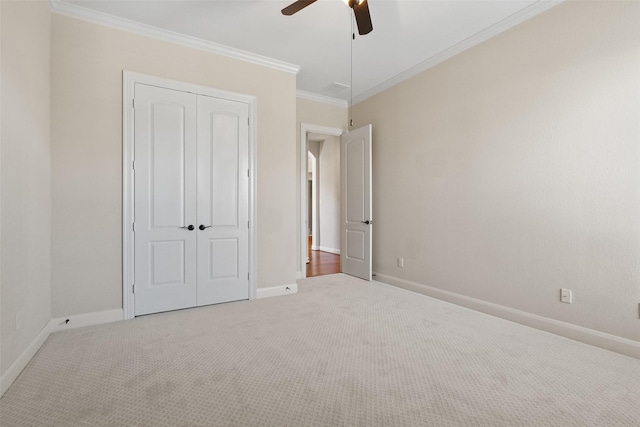 unfurnished bedroom with ornamental molding, a closet, carpet floors, and baseboards