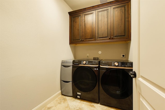 laundry area featuring washer and dryer, cabinet space, and baseboards