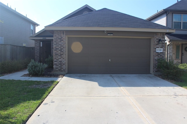 view of front of house with concrete driveway, brick siding, and an attached garage