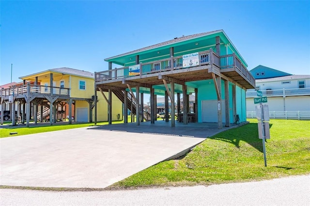 view of front of home with stairs, a carport, concrete driveway, and a front yard