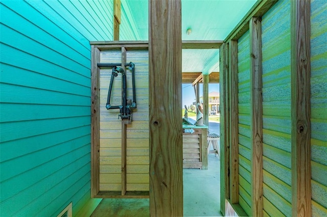 entryway featuring wood walls, concrete floors, and visible vents