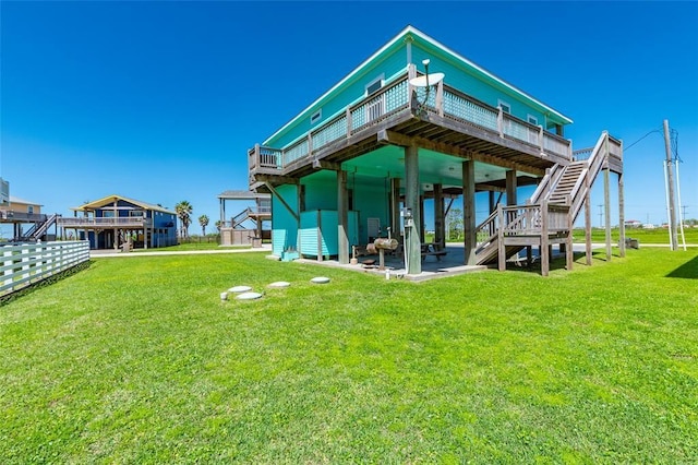 back of house with stairs, a lawn, and a wooden deck