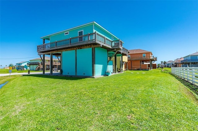 rear view of property featuring a lawn and fence