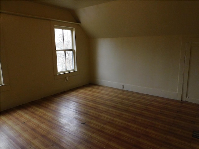 additional living space with vaulted ceiling and wood finished floors