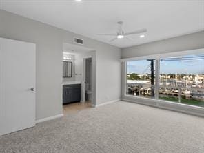 unfurnished bedroom with carpet, visible vents, ensuite bath, and baseboards