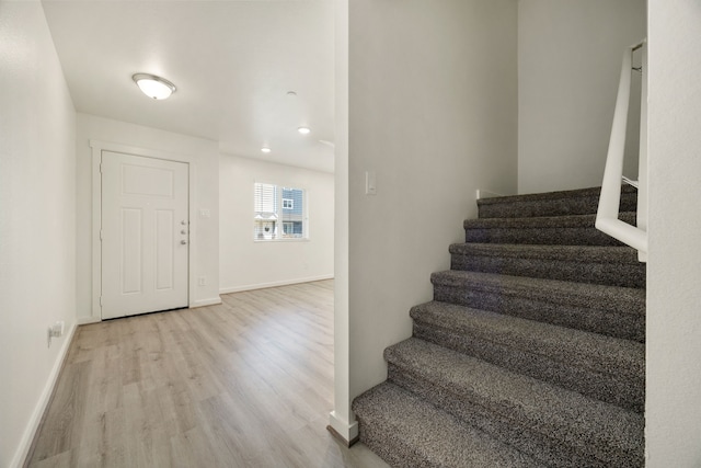 stairway with baseboards and wood finished floors