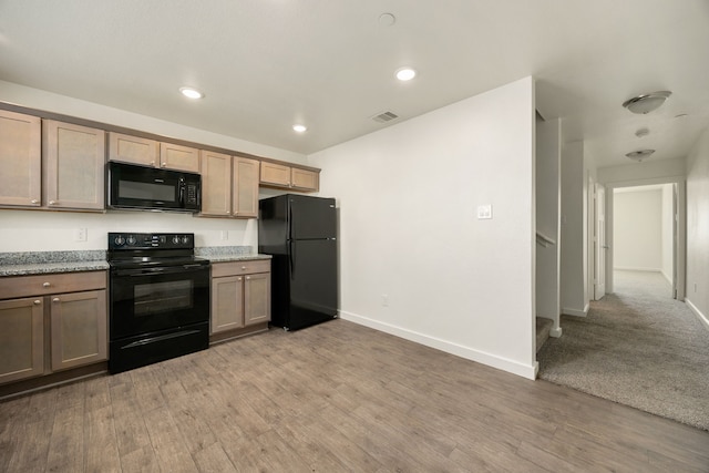 kitchen featuring baseboards, visible vents, light wood-style flooring, and black appliances