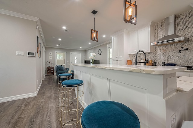 kitchen featuring dark wood-style floors, tasteful backsplash, open floor plan, white cabinets, and wall chimney exhaust hood