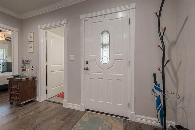 foyer featuring baseboards, ornamental molding, ceiling fan, and dark wood-type flooring