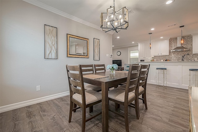 dining room with recessed lighting, dark wood-style flooring, crown molding, and baseboards