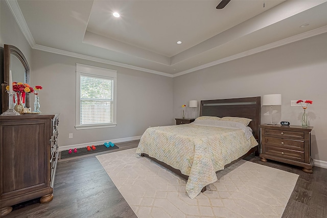 bedroom with a raised ceiling, baseboards, crown molding, and dark wood-style flooring