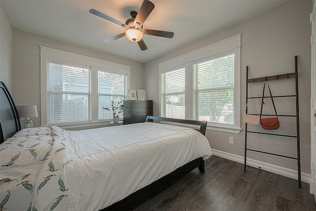 bedroom with ceiling fan, dark wood-style flooring, multiple windows, and baseboards