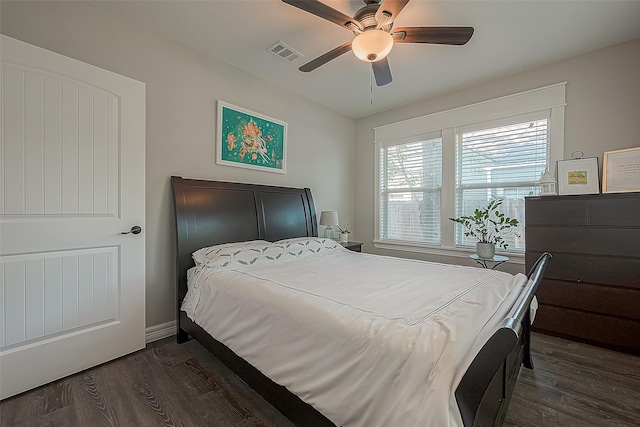 bedroom featuring visible vents, dark wood finished floors, baseboards, and ceiling fan