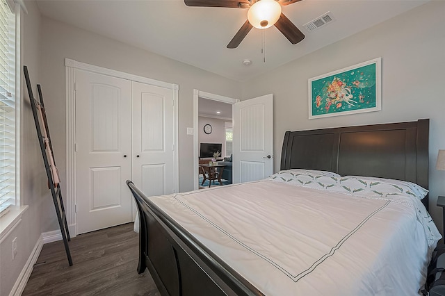 bedroom featuring dark wood-style floors, a closet, visible vents, a ceiling fan, and baseboards