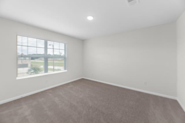 carpeted empty room featuring visible vents and baseboards