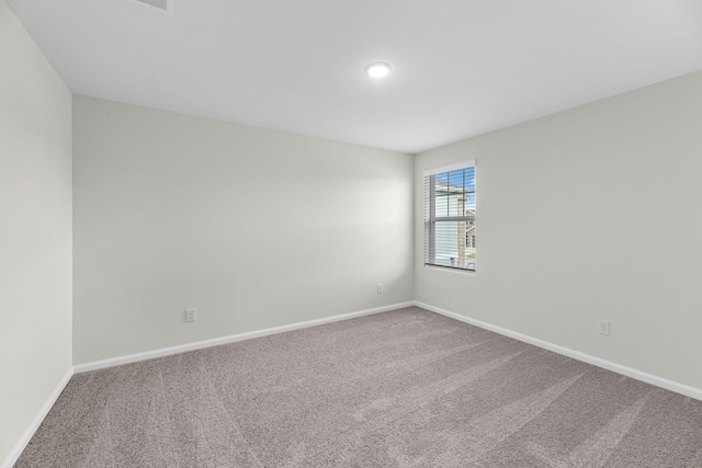 carpeted spare room with baseboards