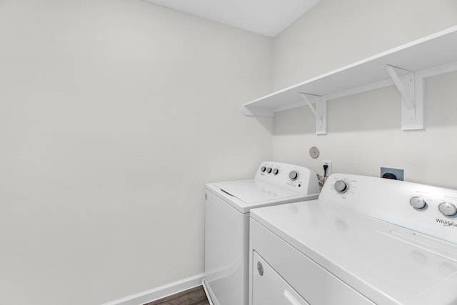 laundry room featuring dark wood-type flooring, laundry area, baseboards, and washing machine and clothes dryer