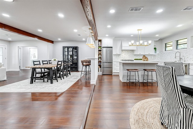 dining space featuring dark wood-style floors, beamed ceiling, visible vents, and recessed lighting