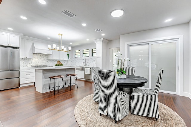 dining area with visible vents, dark wood finished floors, and an inviting chandelier