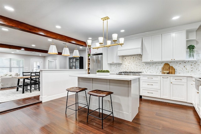 kitchen with a center island, custom exhaust hood, dark wood-style flooring, and freestanding refrigerator