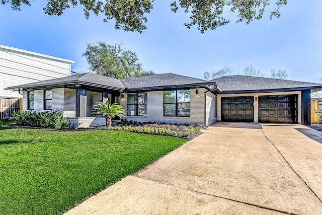 prairie-style home featuring concrete driveway, brick siding, an attached garage, and a front lawn