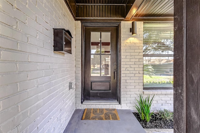 doorway to property featuring brick siding