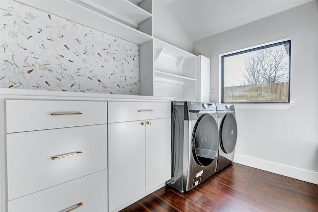 laundry area featuring dark wood-style floors, cabinet space, washer and clothes dryer, and baseboards