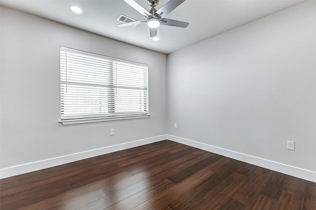 empty room featuring dark wood-style floors, ceiling fan, visible vents, and baseboards