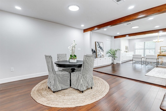 dining space with visible vents, an inviting chandelier, wood finished floors, beamed ceiling, and baseboards