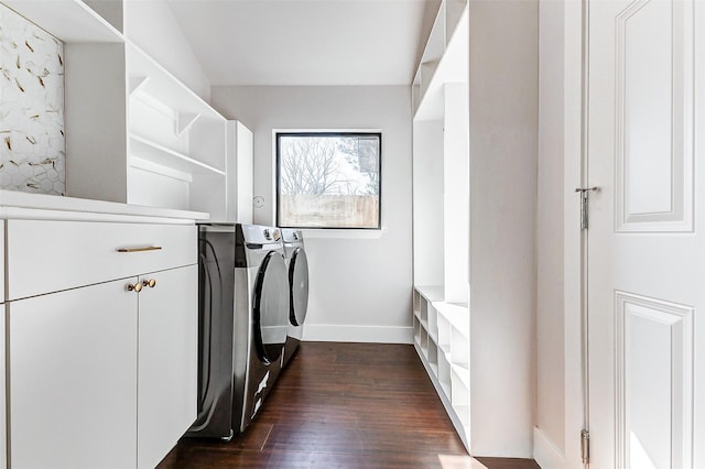 washroom with separate washer and dryer, dark wood-style flooring, cabinet space, and baseboards